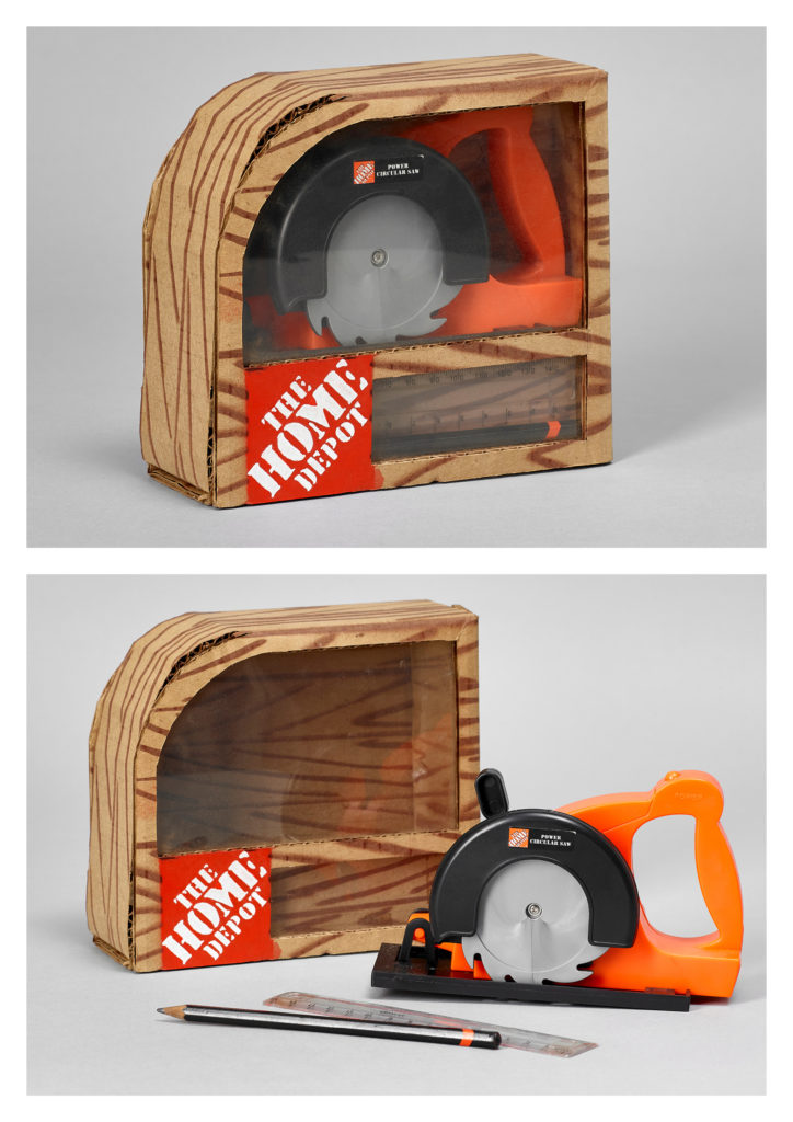 The packaging for this toy saw is handmade, using corrugated cardboard and spray paint.